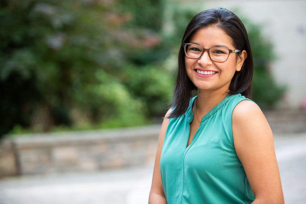 Profile picture from Joscelin sitting at a courtyard smiling